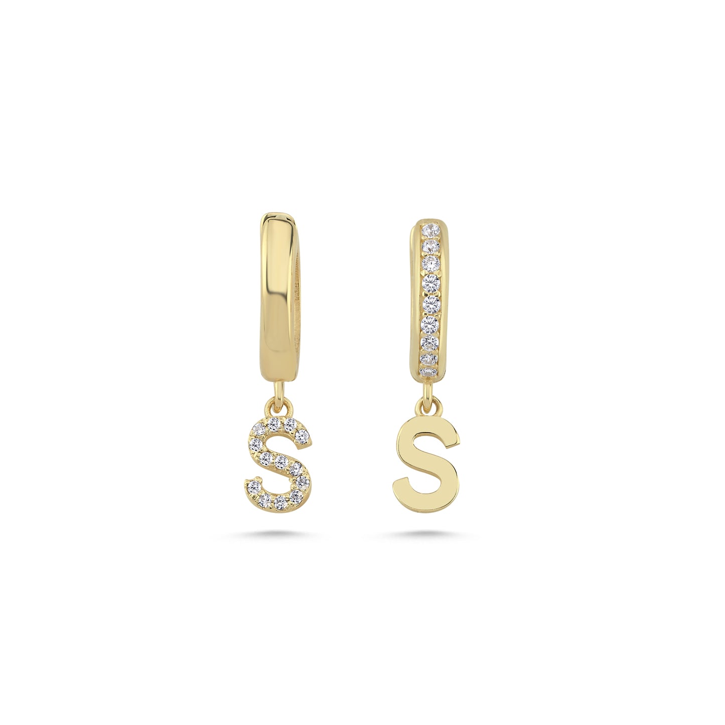 Close up of solid gold letter earrings with diamond accents.