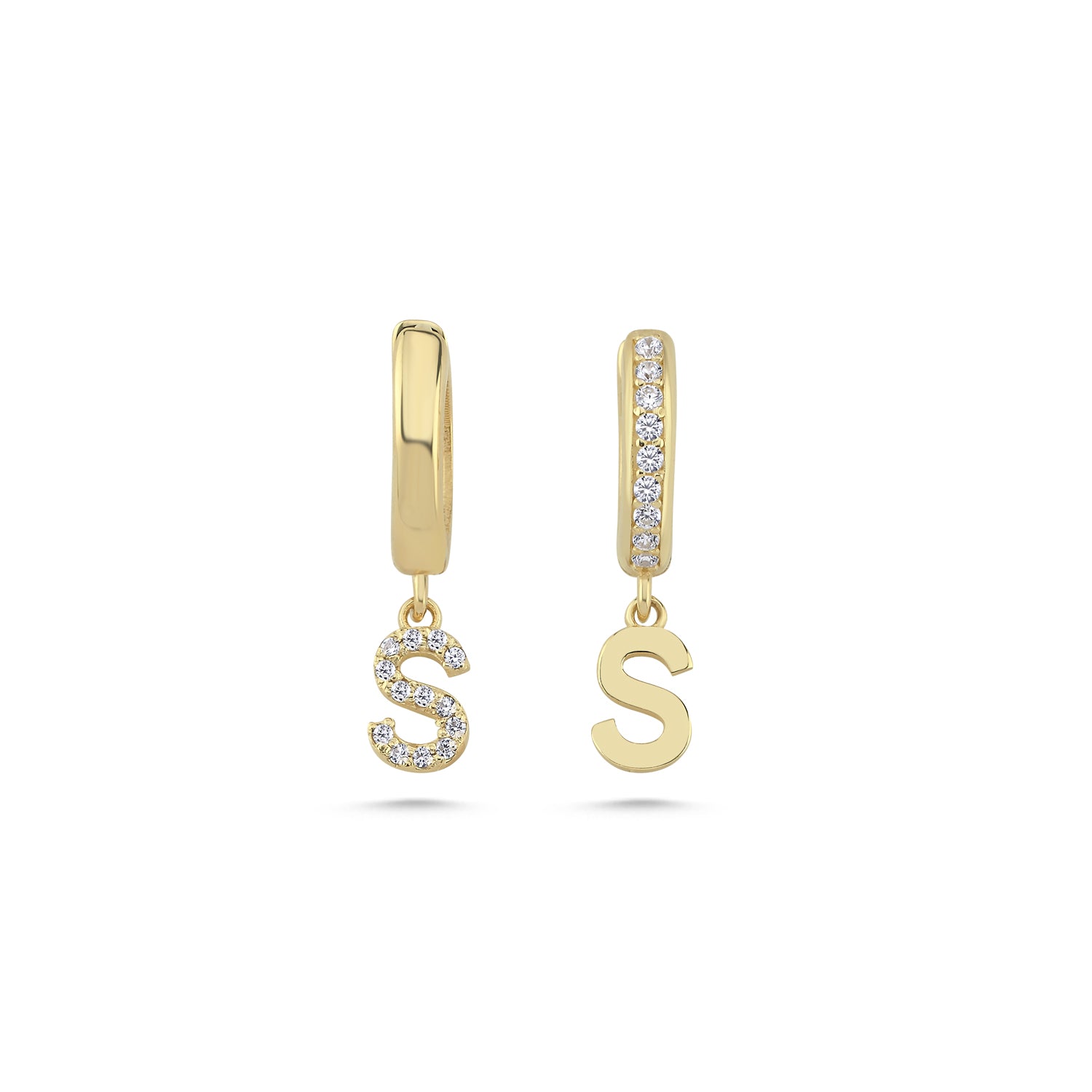 Close up of solid gold letter earrings with diamond accents.