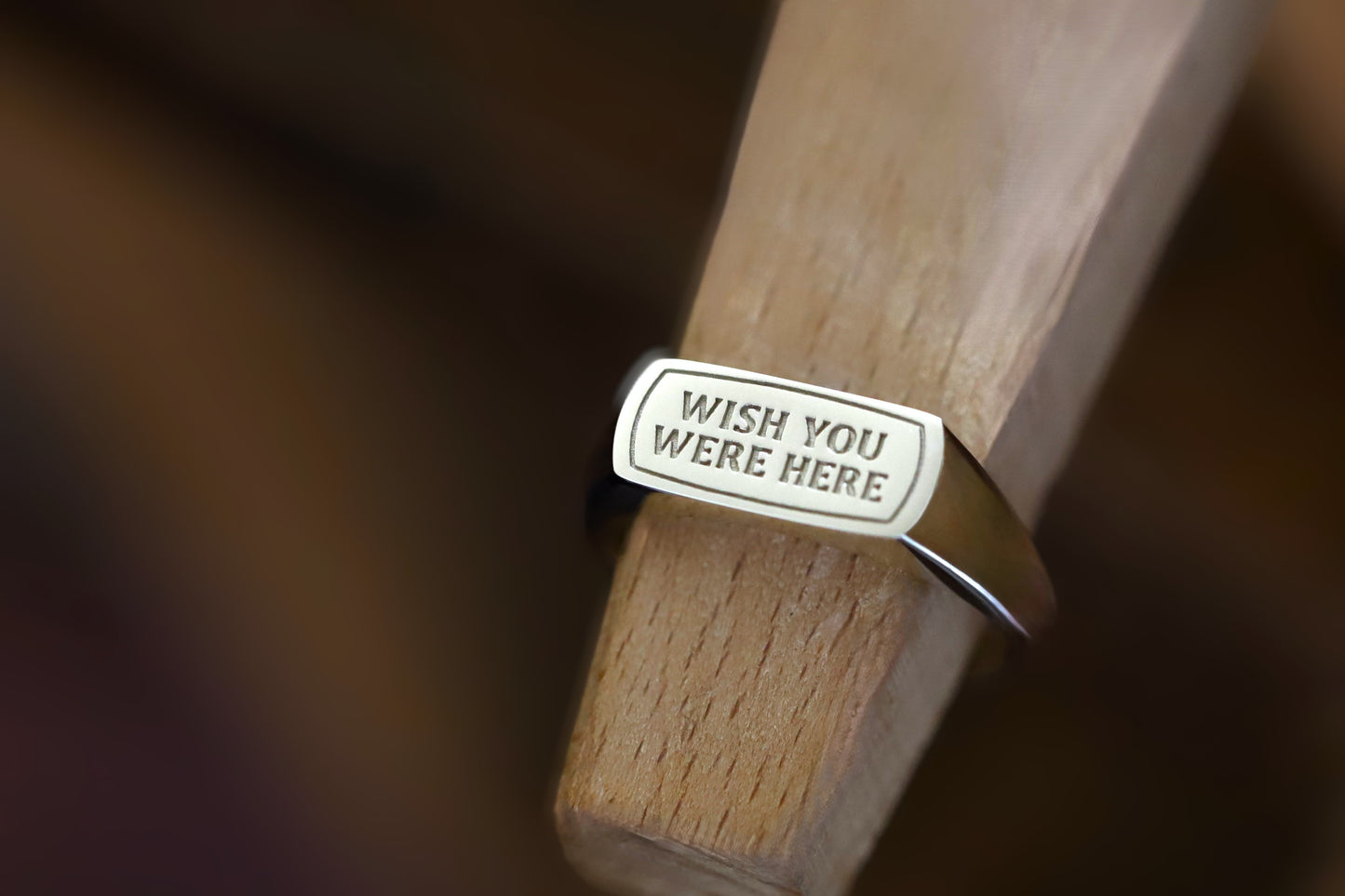 Close up of a deep detailed engraving on a solid gold inspirational quote jewelry ring.