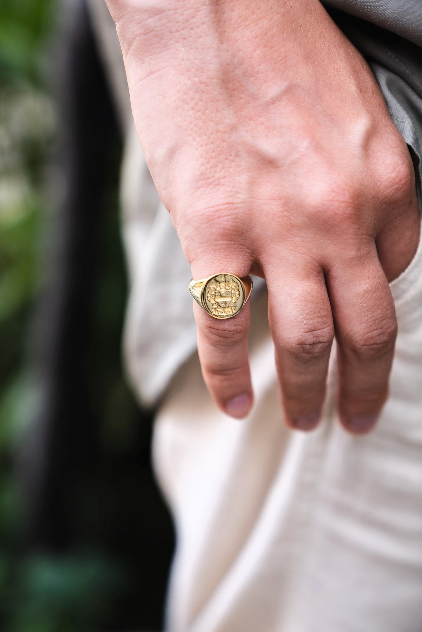 Close-up of a solid gold signet ring on a men's pinky