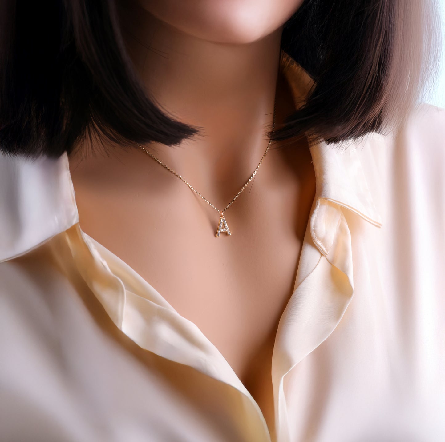 Diamond paved letter a initial pendant worn by a female model