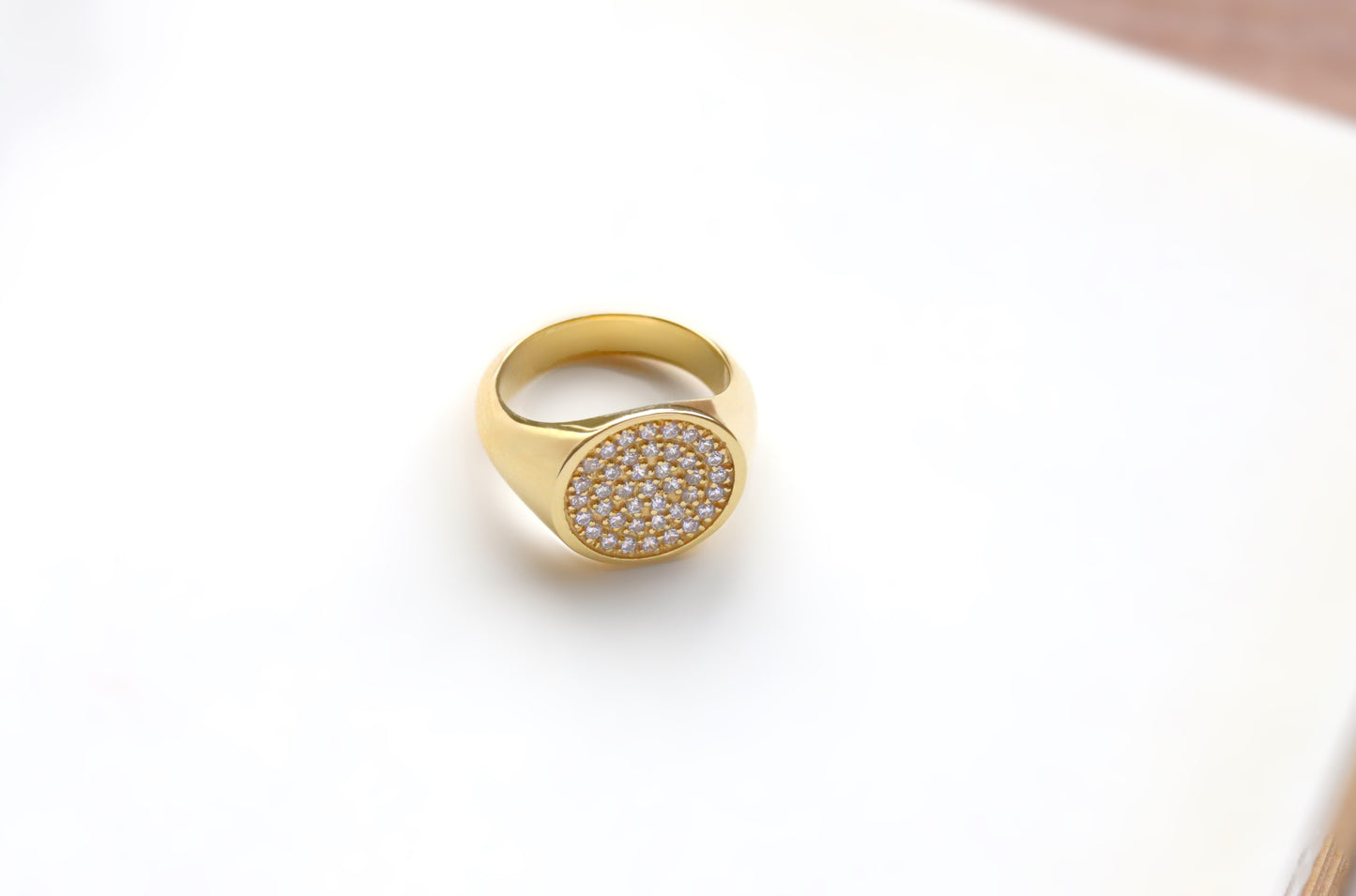 Close up of a 14k gold signet ring with diamonds