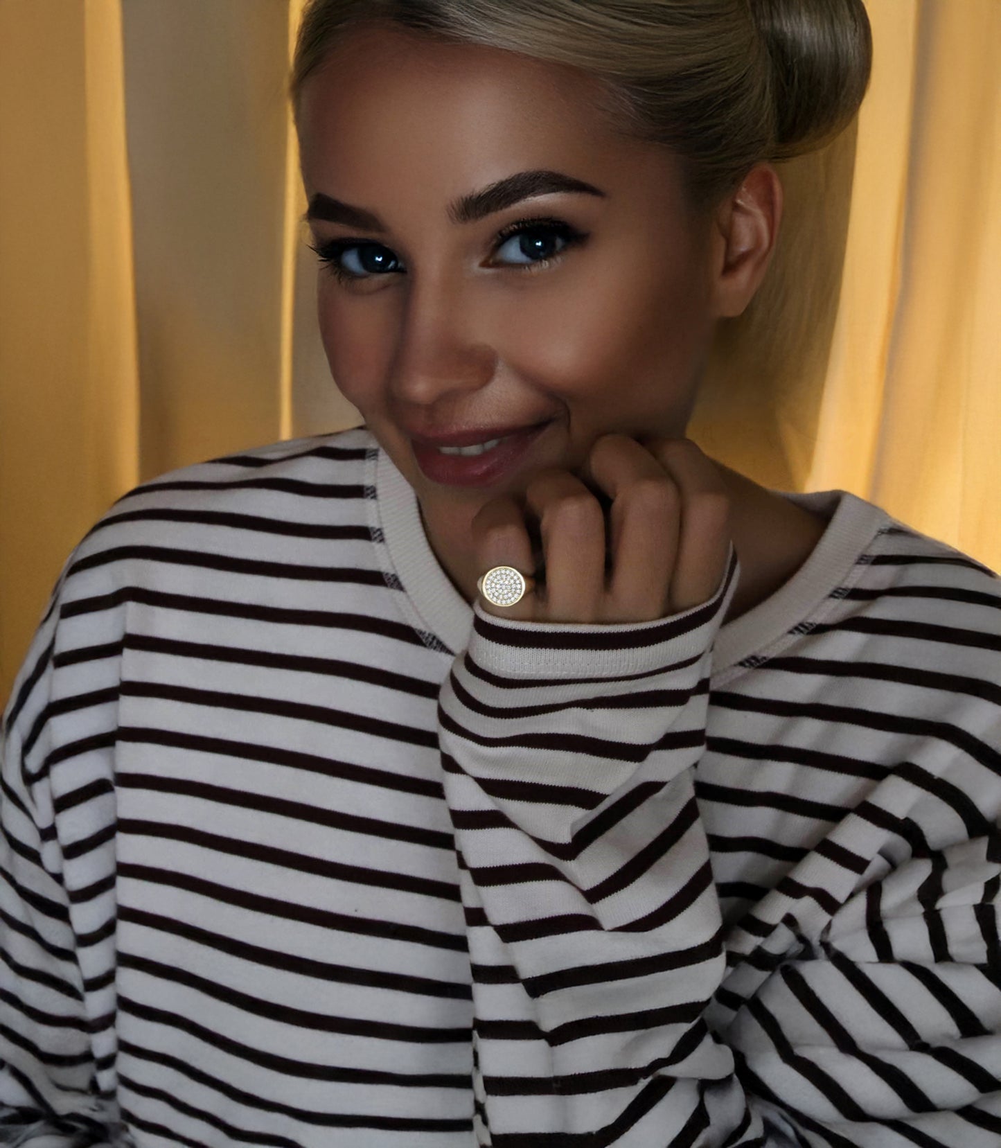 Woman wearing a solid gold diamond paved signet ring