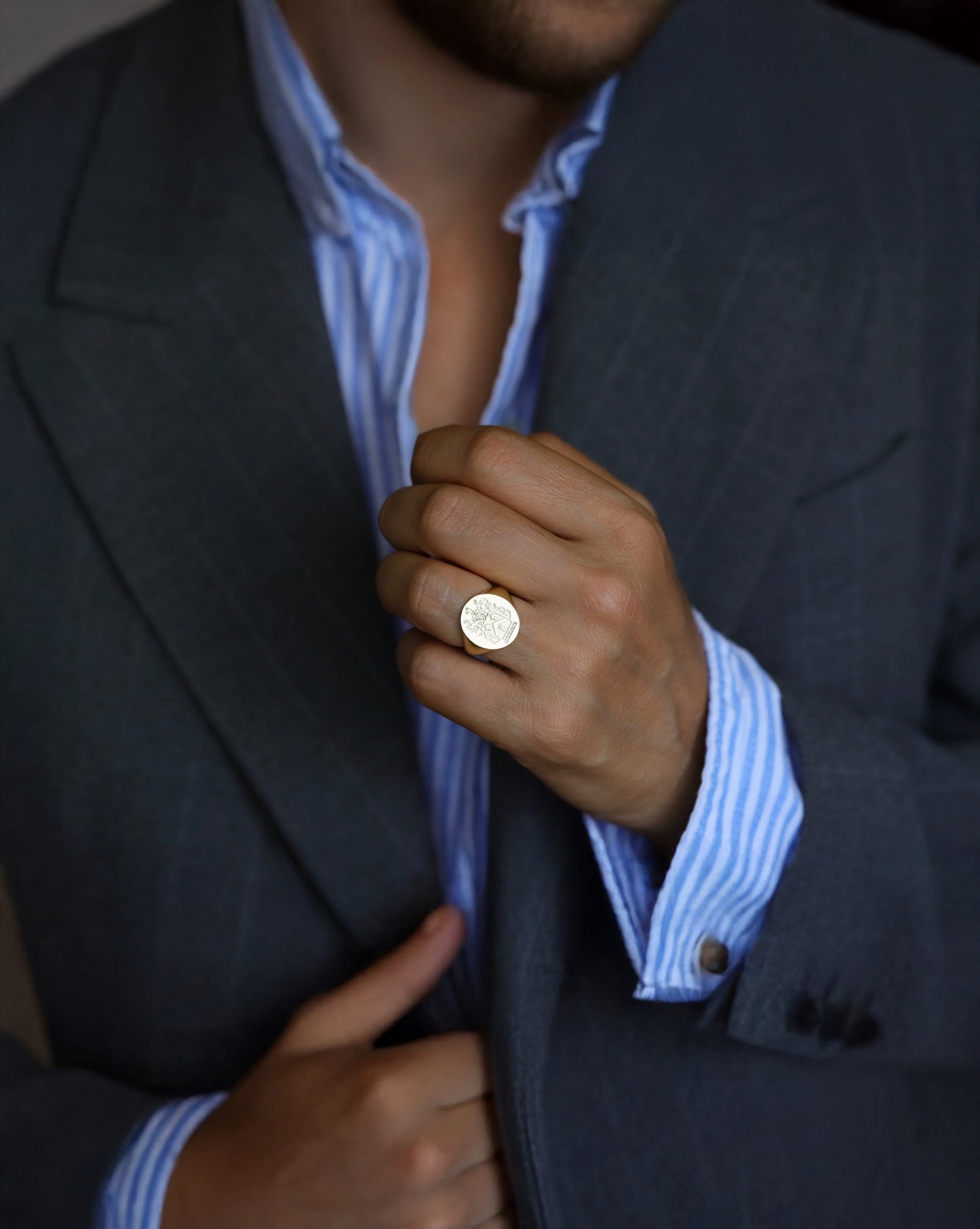 close-up of a gold signet ring on a man's hand