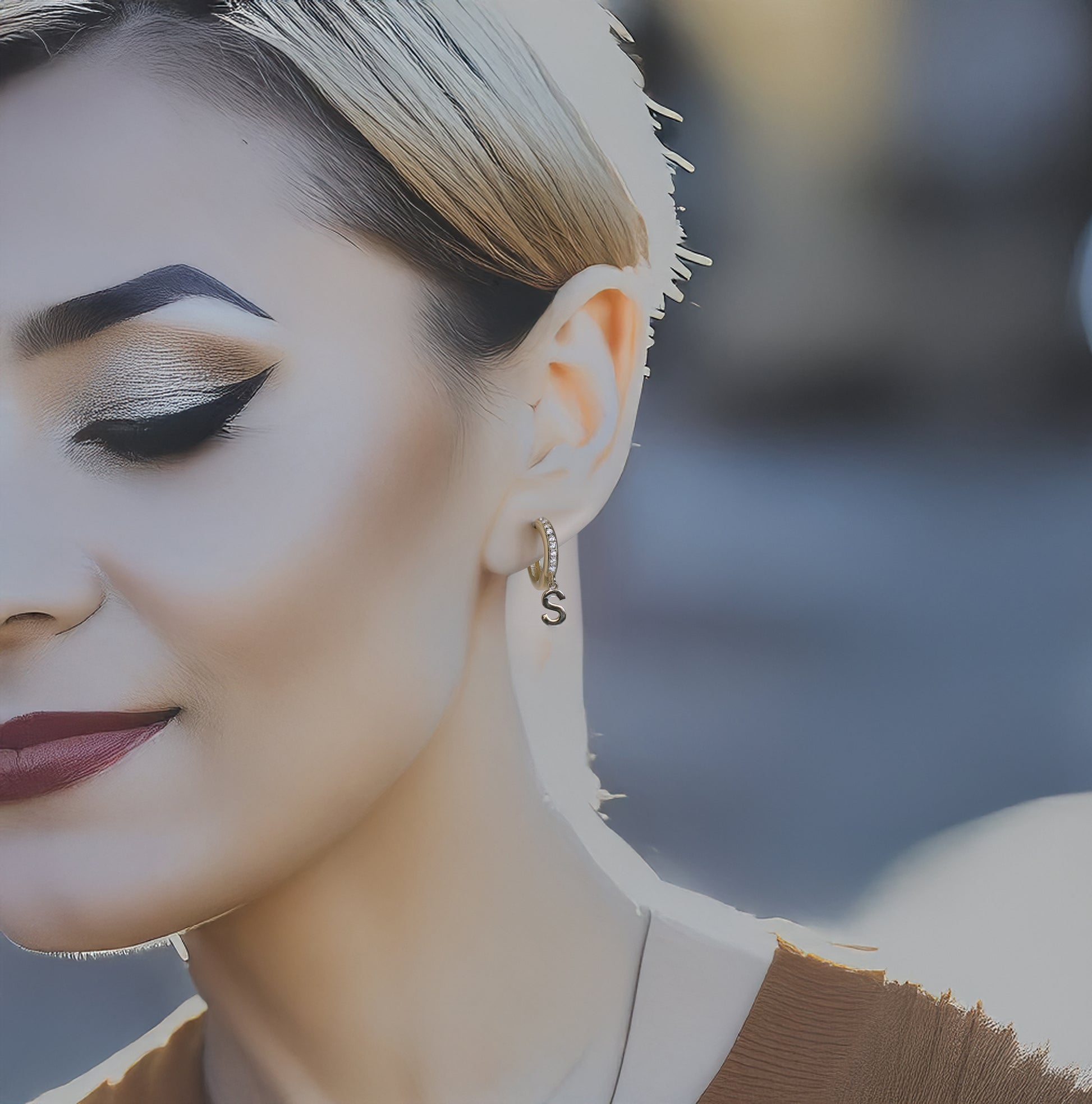 Close-up of a model wearing gold initials earring