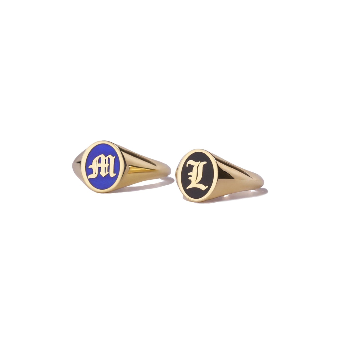 Two gold signet rings with initials with blue and black enamel  on a white background
