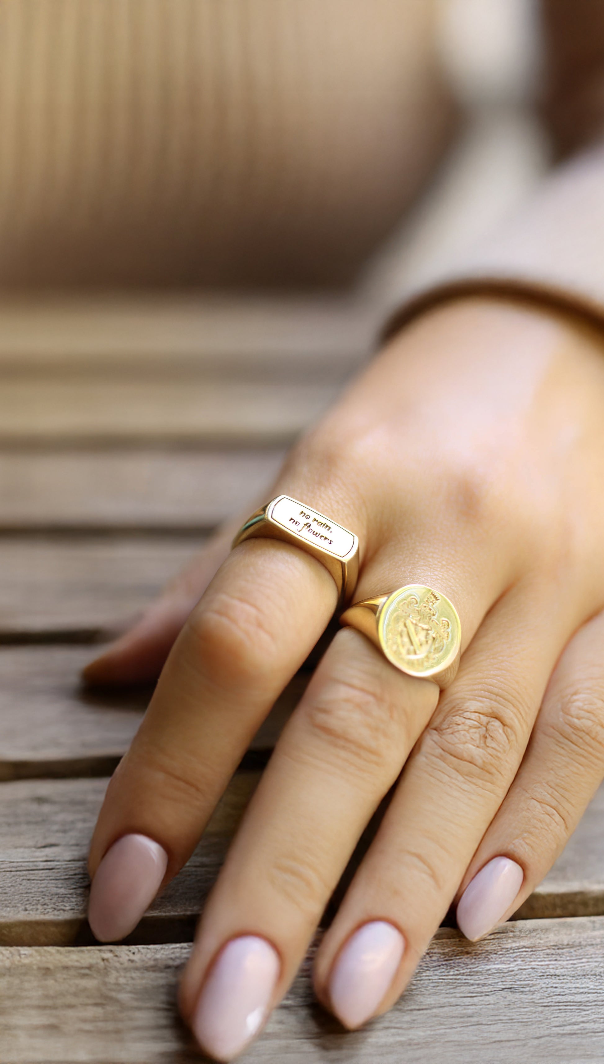 Womens gold rectangle signet ring worn on the index finger.