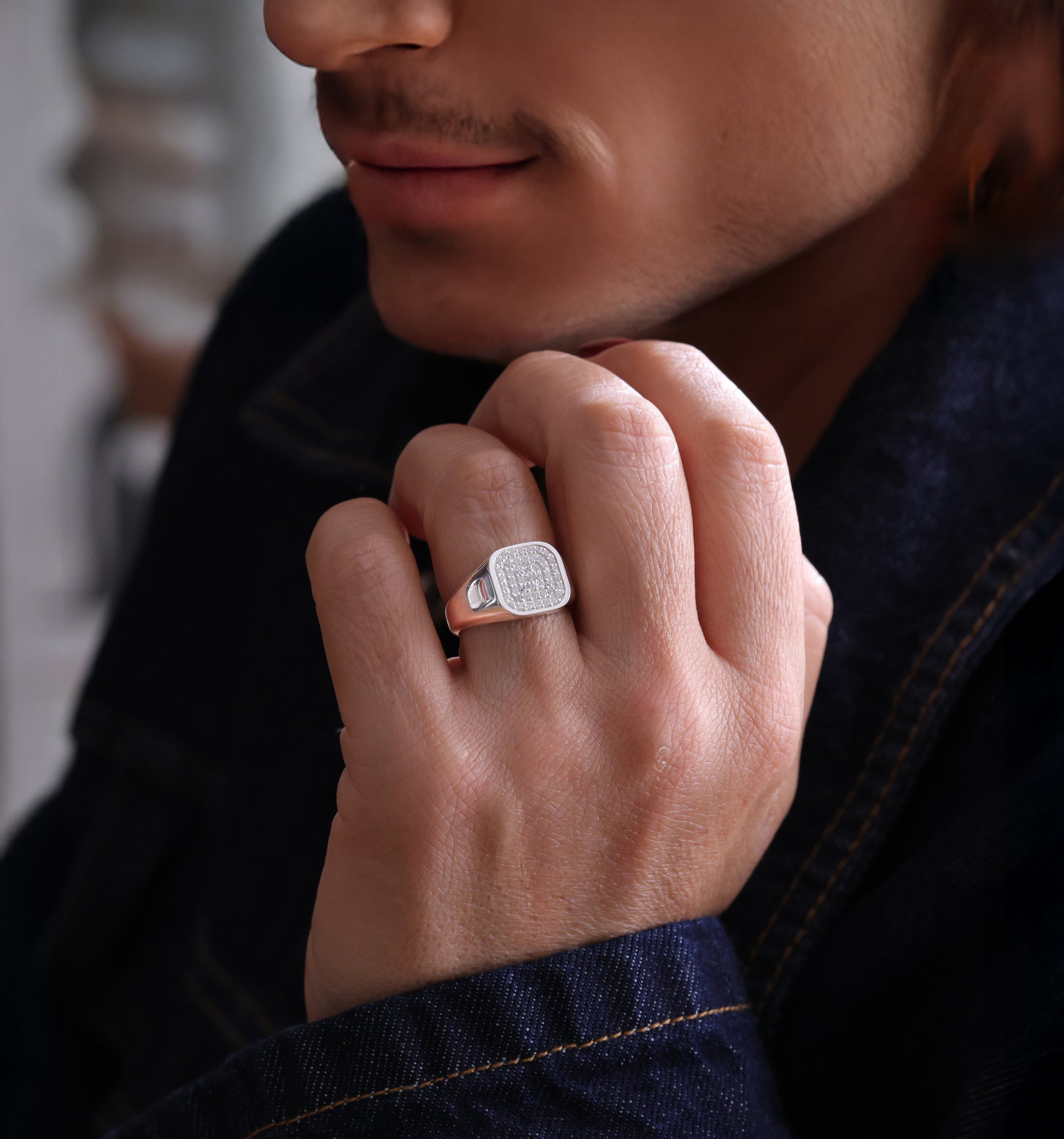 Men's paved pinky ring worn on hand.