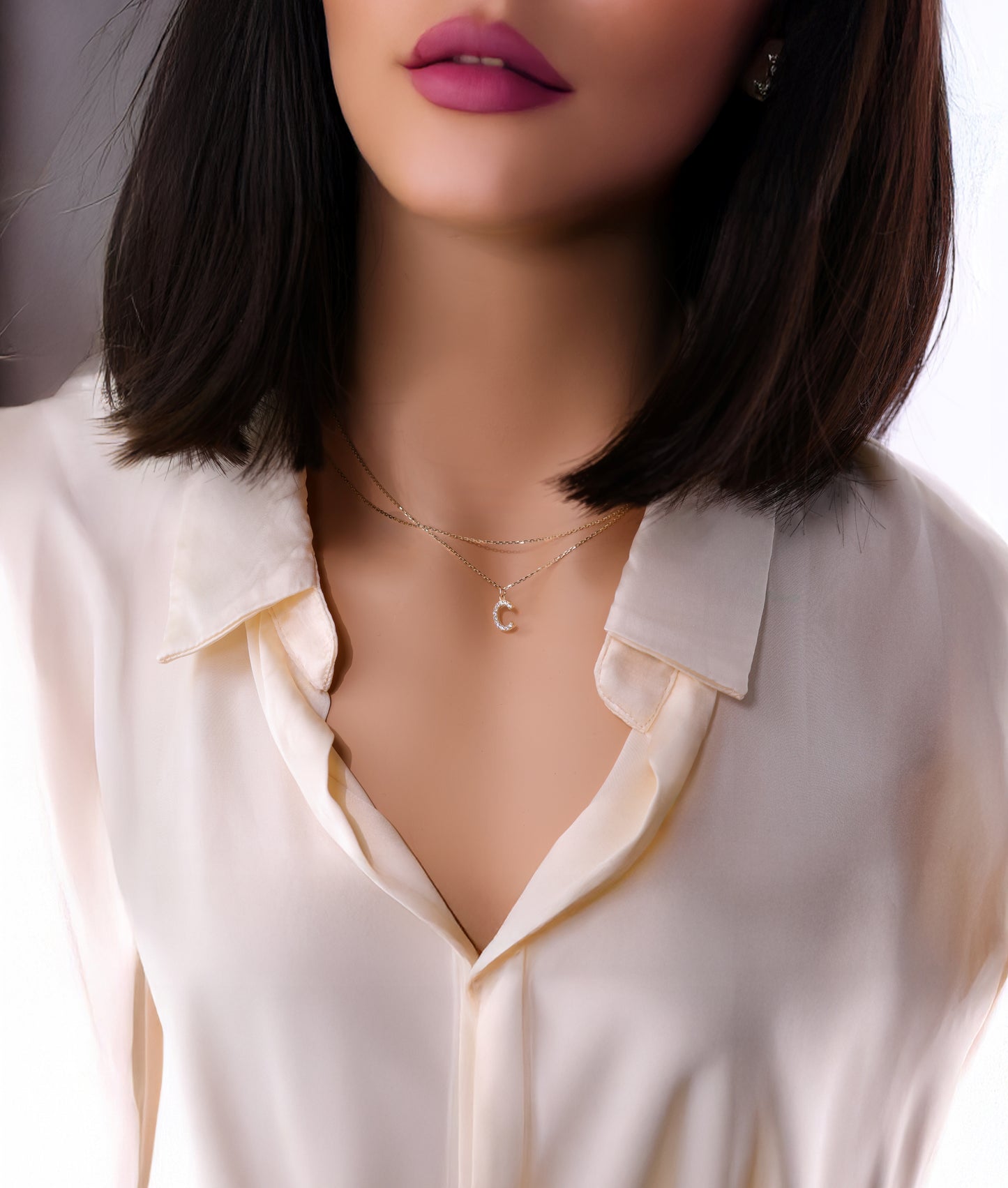 Solid 14k yellow gold necklace featuring a diamond paved letter c initial pendant worn by a model.