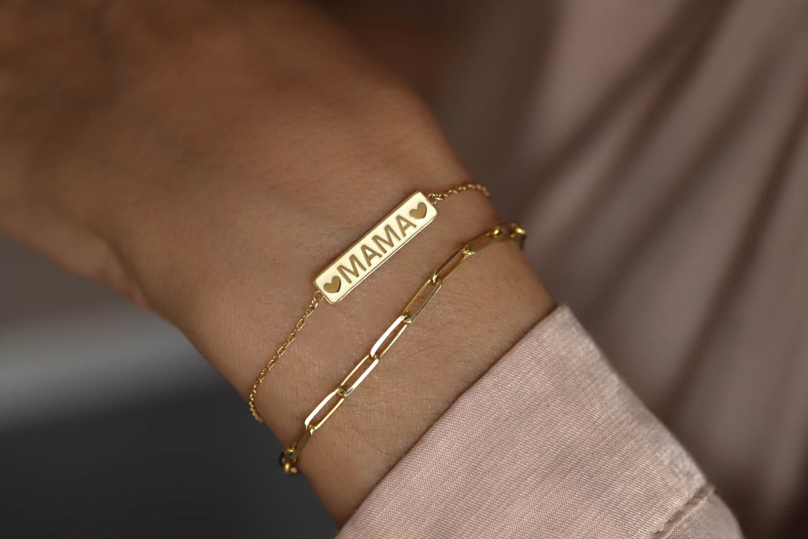 Modern mother wearing the solid gold mama bracelet layered with everyday fine jewelry.