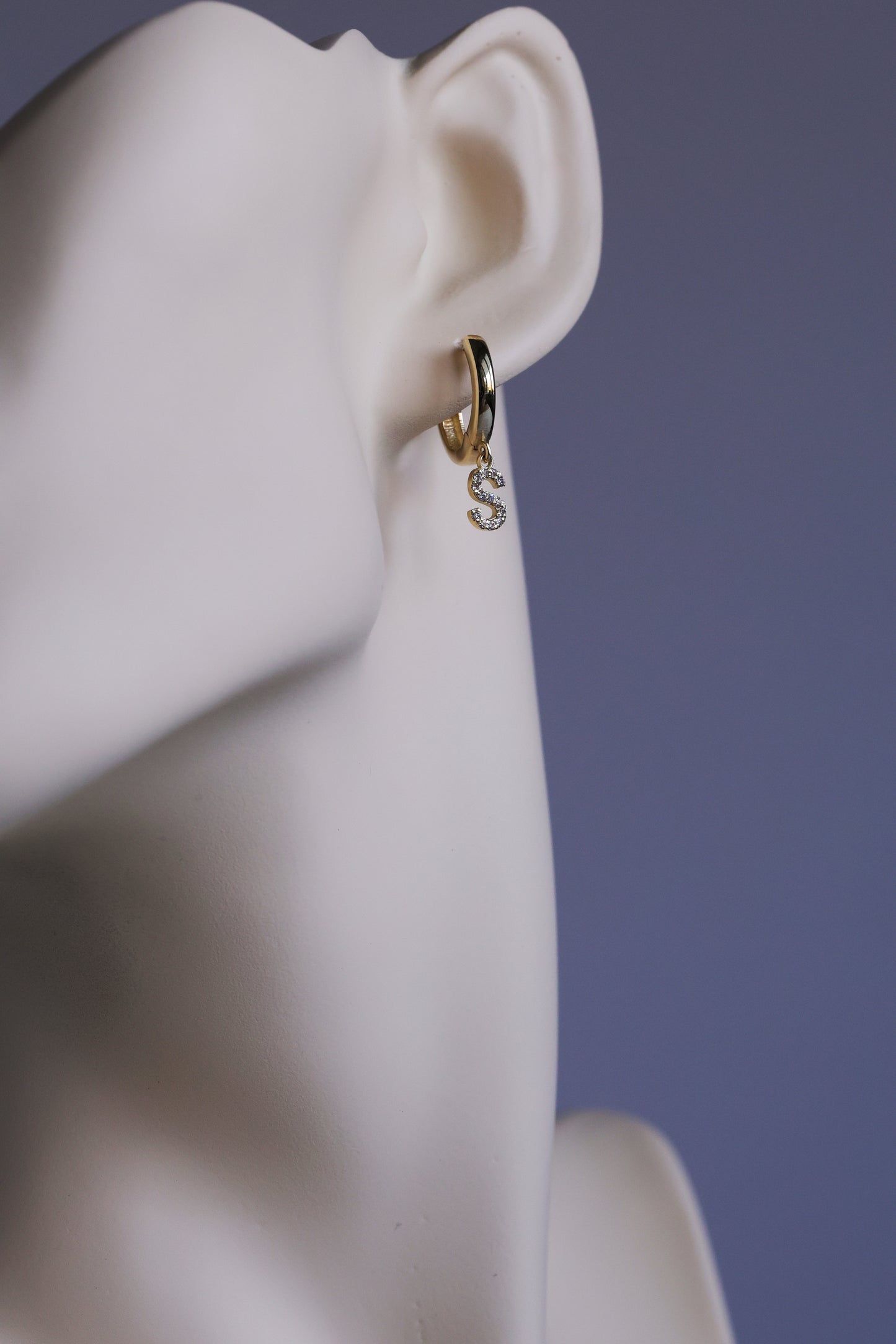 Gold hoop earring with 'S' initial charm paved with real diamonds on a mannequin ear 