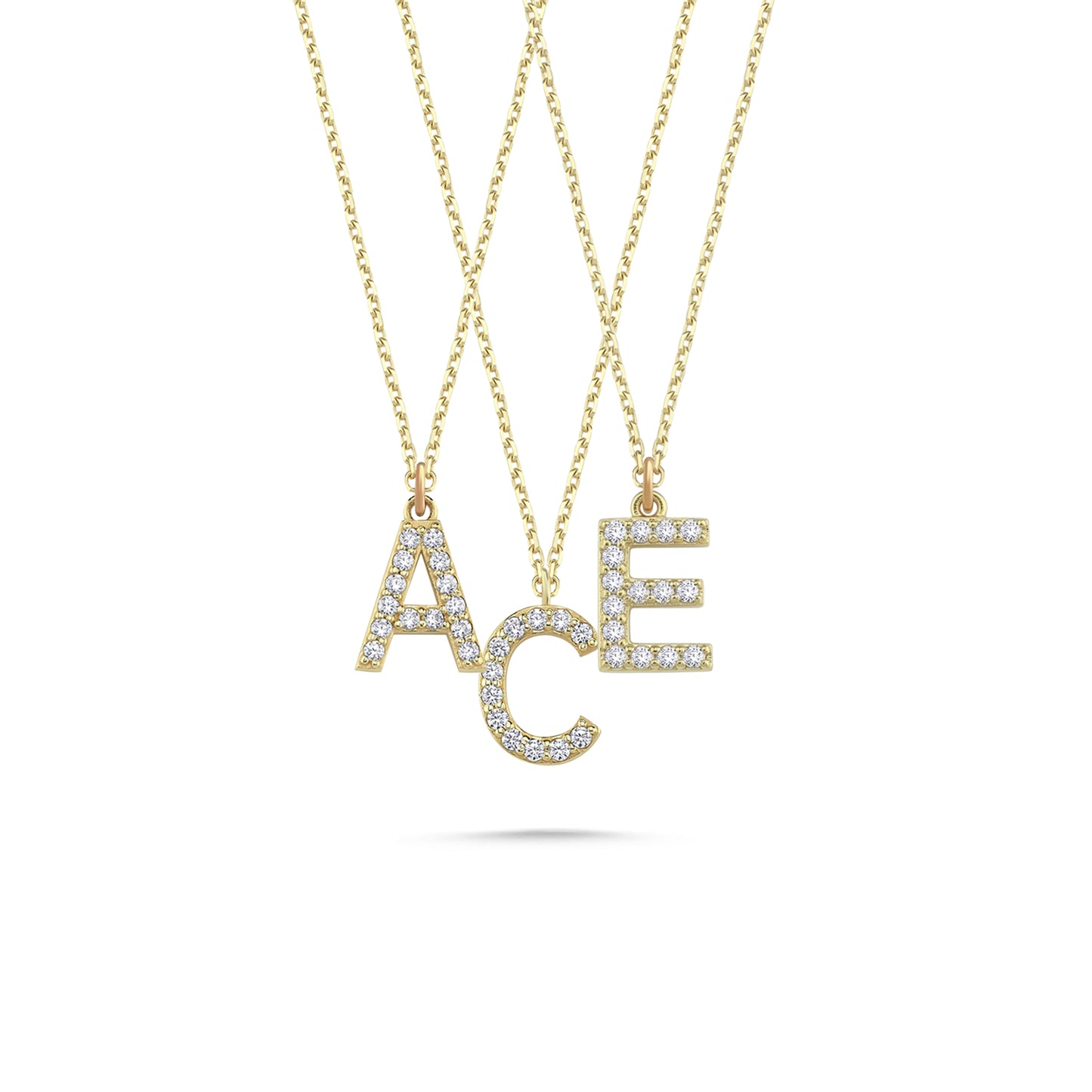 Three solid gold diamond paved initial necklaces featuring the letters A, C, and E.