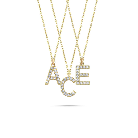 Three solid gold diamond paved initial necklaces featuring the letters A, C, and E.