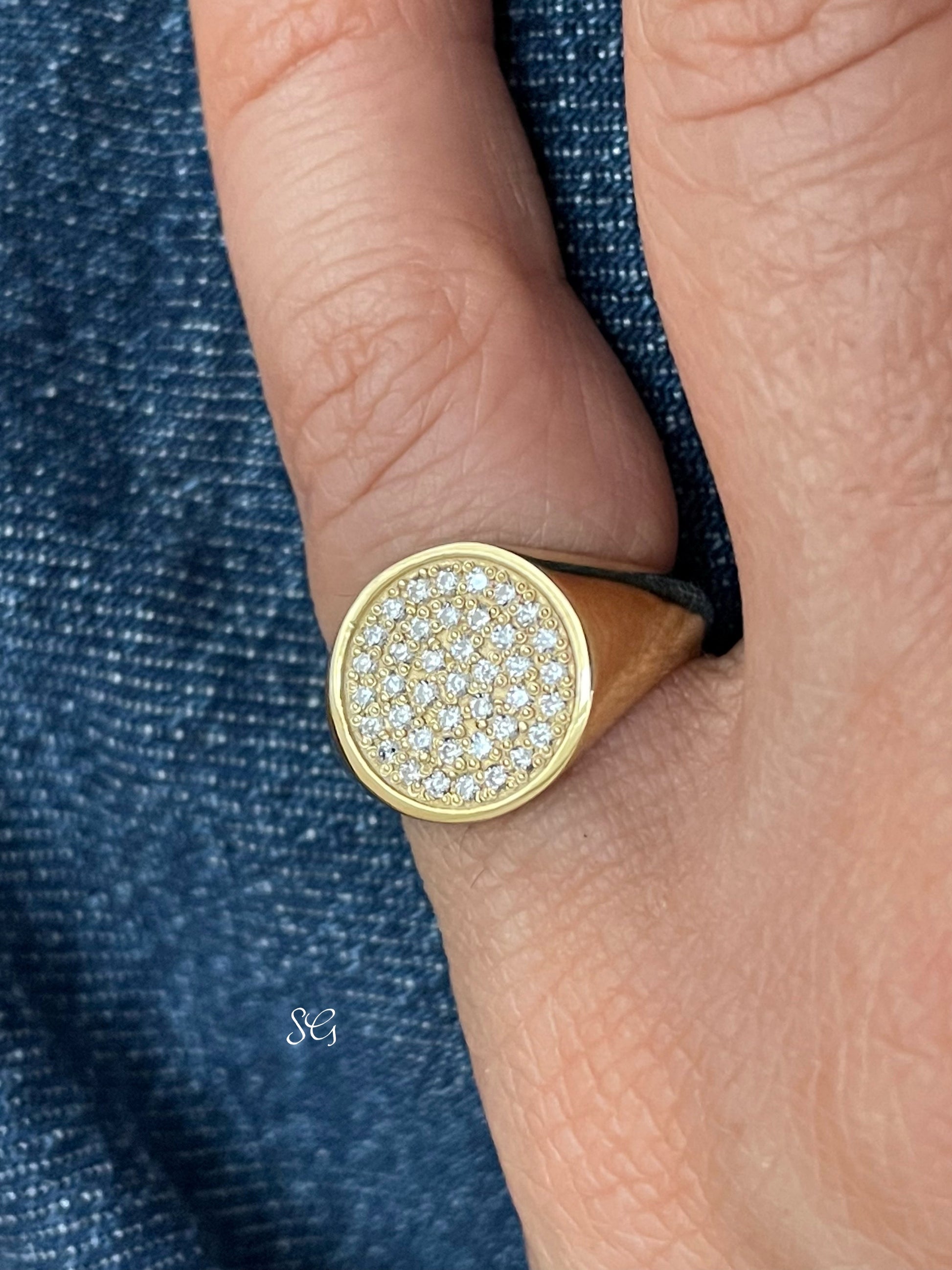 Solid 14k gold diamond paved signet ring, worn prominently on a womens pinky finger.