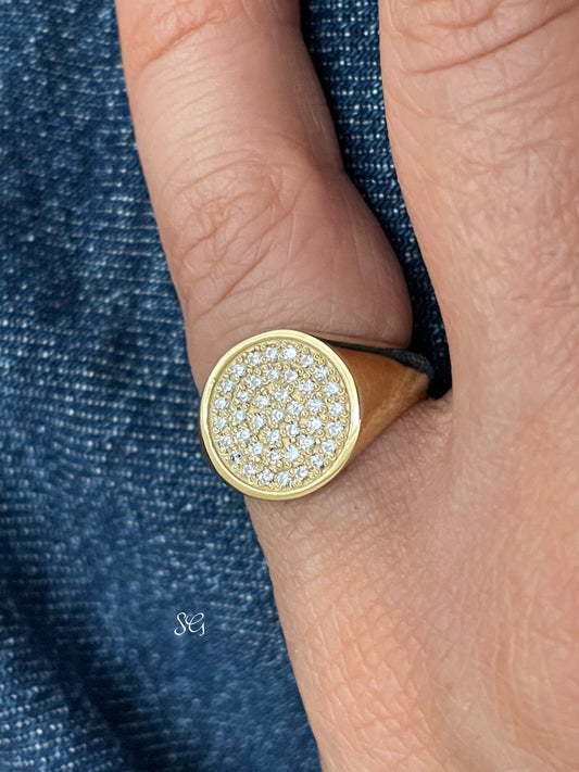 Solid 14k gold diamond paved signet ring, worn prominently on a womens pinky finger.